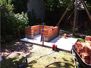 Sockel für den Ofen aus Betonsteinen, aufgemauert mit Ziegel.