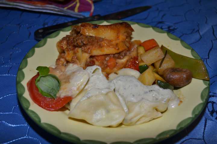 Ein Teller mit den Hauptspeisen Tortellini mit Käserahmsauce,Lasagne und Gemüsepfanne mit Maronen