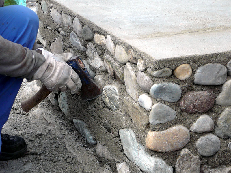 Bearbeitung des Sockels mit einem Handbeil, um den überschüssigen Beton zu entfernen.