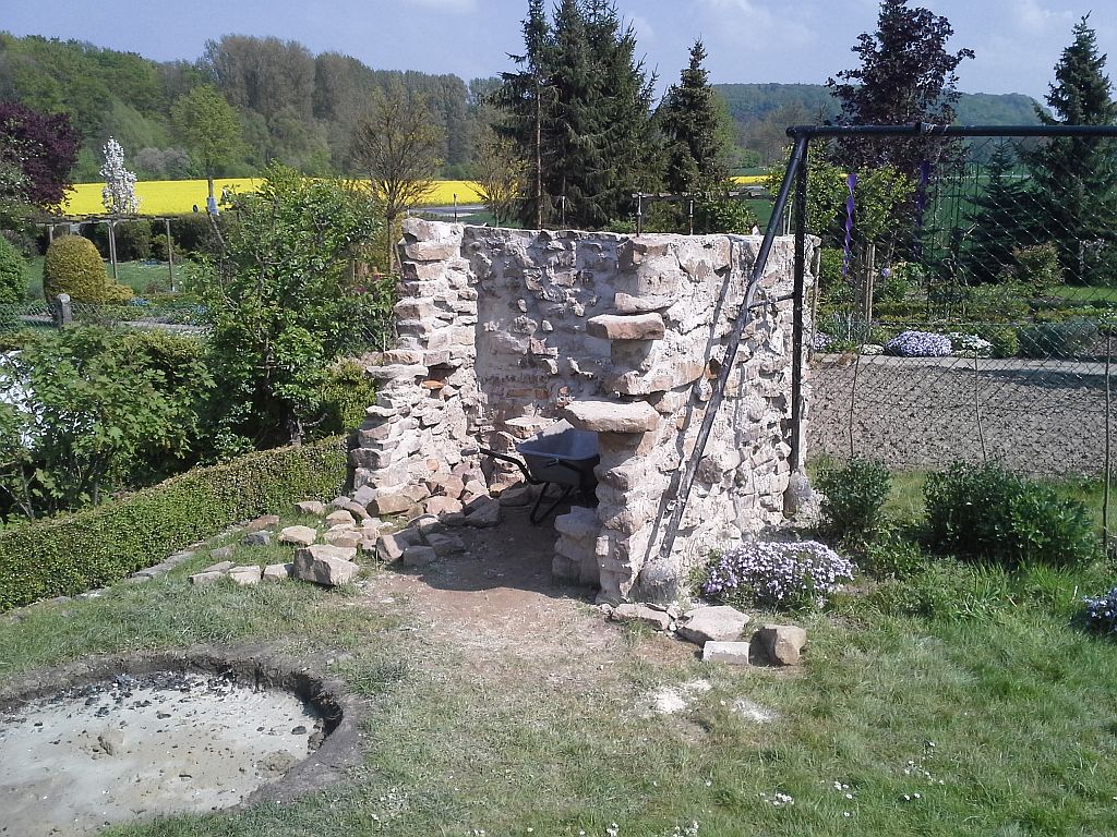 Im Vordergrund nun schon der Aushub für die Grillstelle . Übrigens die zwei Steinplatten an der Mauer sind drehbar
