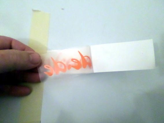 Jetzt auf der einen Seite die Übertragungsfolie mit Folie vom Trägerpapier abheben. Ggf. mit dem Cutter nachhelfen, wenn ein Buchstabe nicht so mit will ...