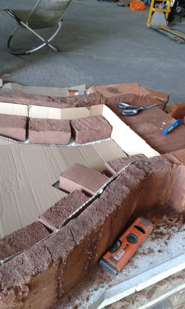 Dann noch eine Reihe liegend, und Du kannst mit der Kuppelwölbung beginnen. Auf die auf der Isolierung liegenden Ziegel kommt noch ca 2cm Dickbett Ton und die Biberschwänze, welche die Bodenplatte bilden. Also noch mal ca. 4cm. So viel halt, daß es eine ebene Fläche mit der &quot;Einfahrt&quot; bildet.