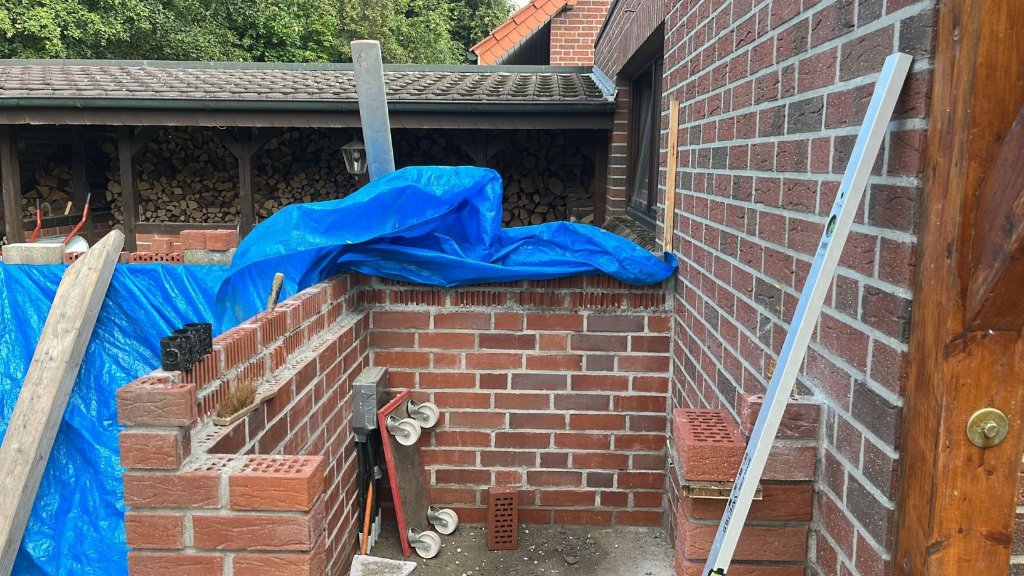 Endlich sind wir in der Höhe der Betonplatte angekommen. Die letzten zwei Reihen haben wir mit nur halben Steinen gemauert. Diese ergeben die Schalung. In der Garagenwand haben wir in der passenden Höhe auch den halben Klinker entfernt um der Betonplatte eine gute Auflage zu ermöglichen.