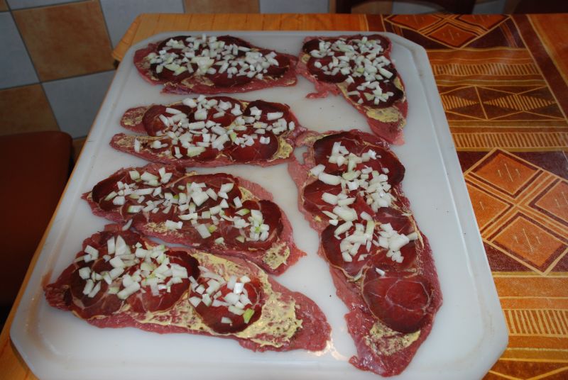 Die Rouladen mit Zwiebeln belegt