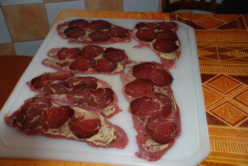 Die Rouladen mit Wildschweinschinken belegt.